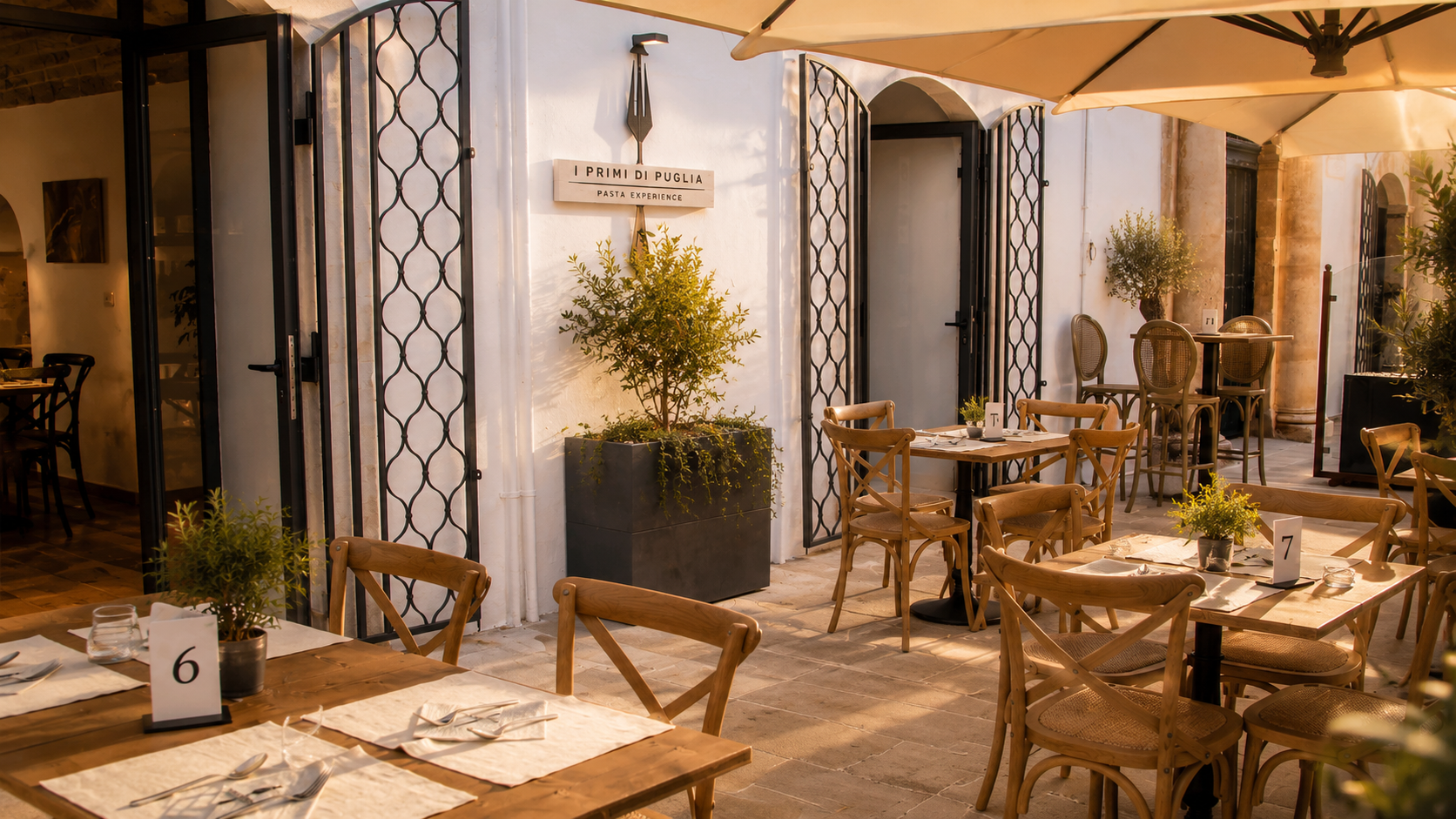 Esterno del ristorante I Primi di Puglia ad Alberobello al tramonto, con ingresso illuminato e scorcio dei trulli